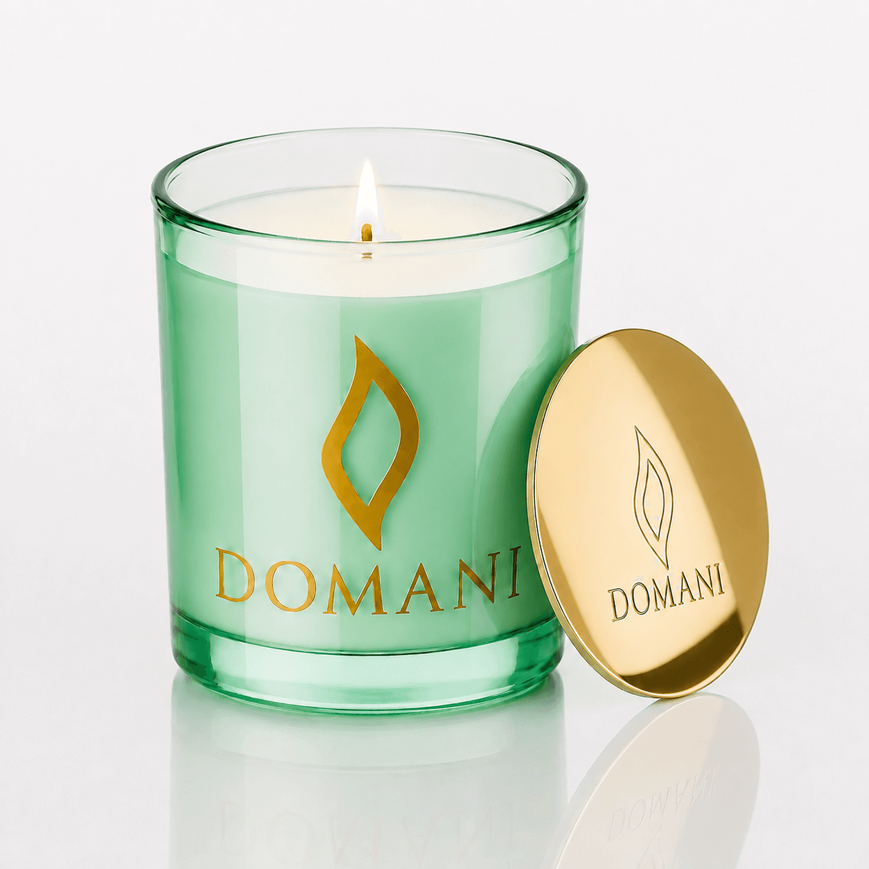 Domani Philos candle, Emerald · Lit candle, downward view