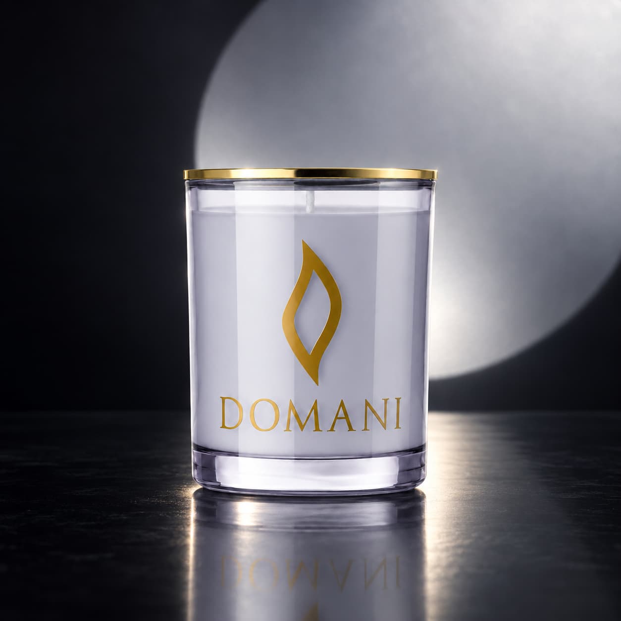Domani luna diamante candle in Sapphire glass, on a dark reflective surface before a silver light circle. Also available in the other three jar colors.
