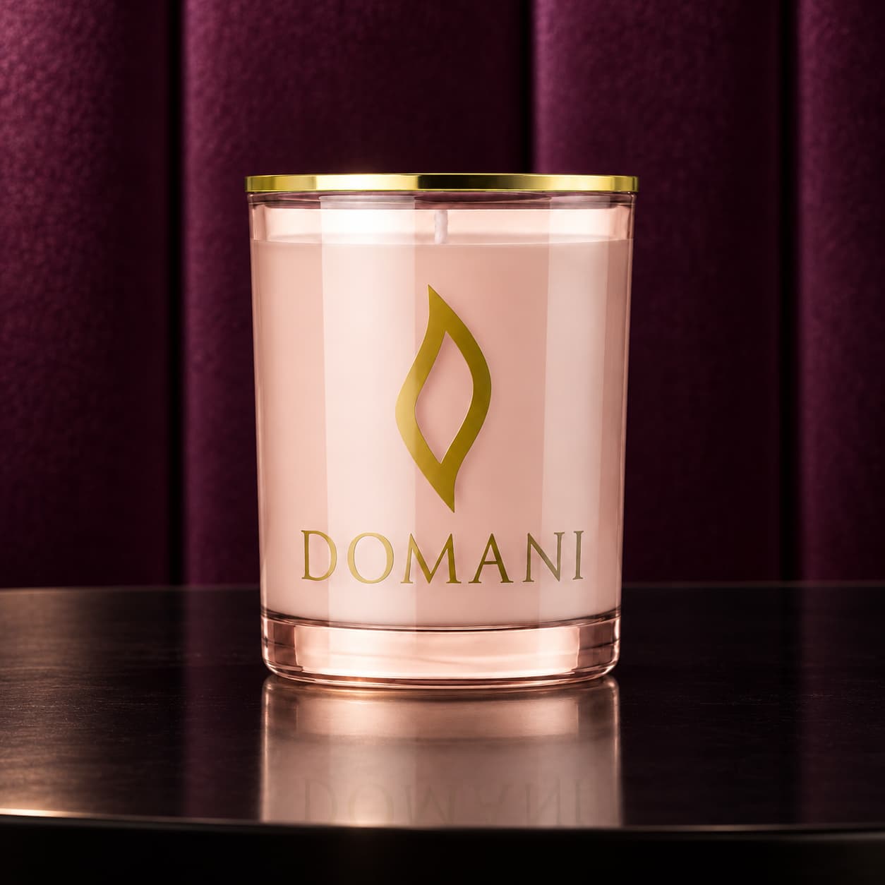 Domani velvet kiss candle in Rose Quartz glass, on black lacquer before aubergine velvet. Also available in the other three jar colors.