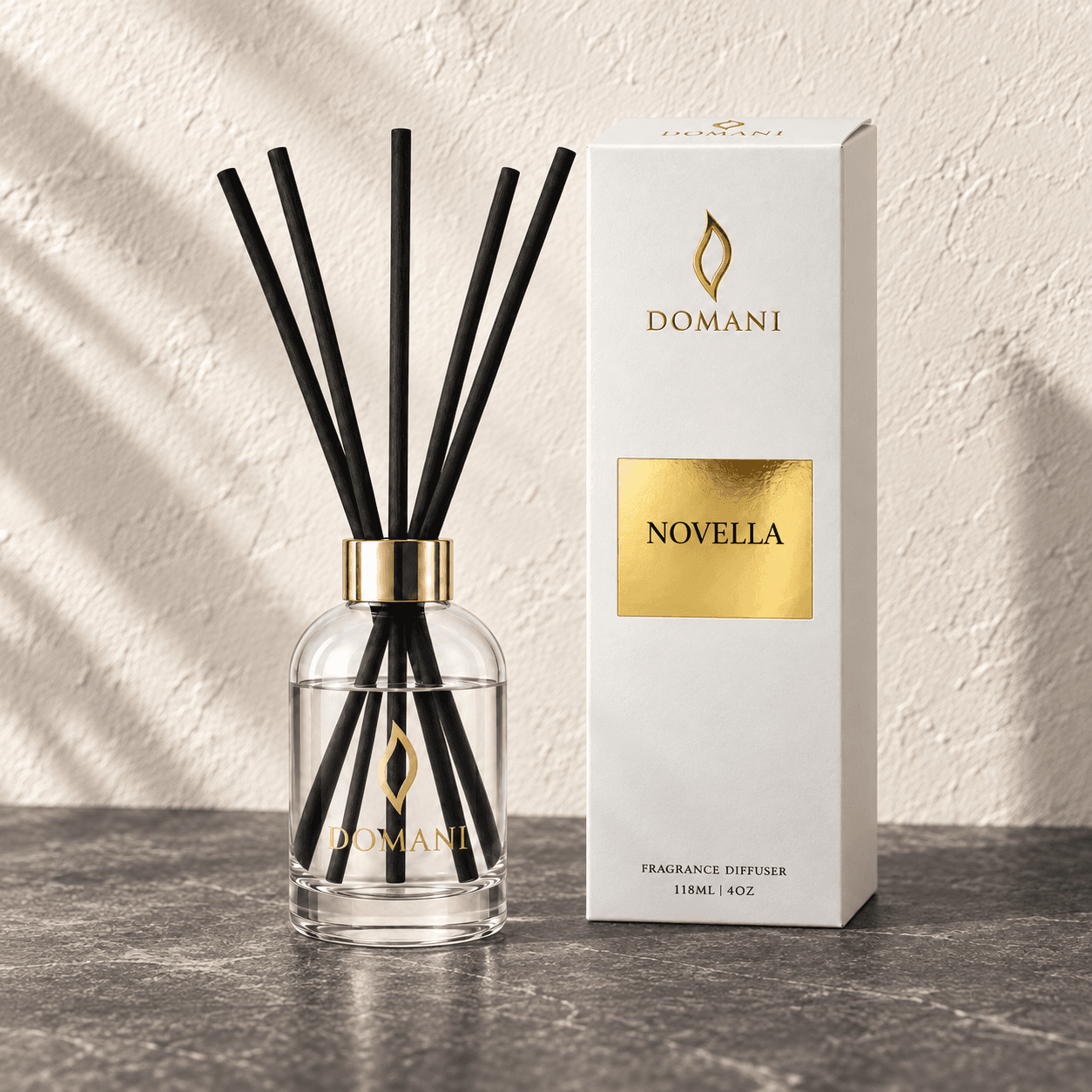 Novella reed diffuser with five reeds beside a carton bearing its fragrance name