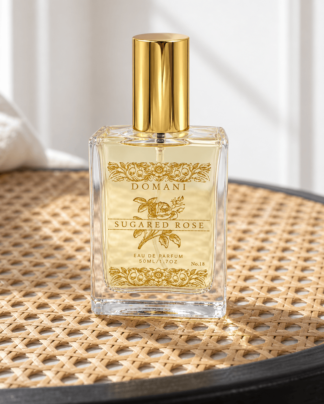 The complete Sugared Rose 50 ml eau de parfum, viewed nearly front-on on a close area of woven cane seating.