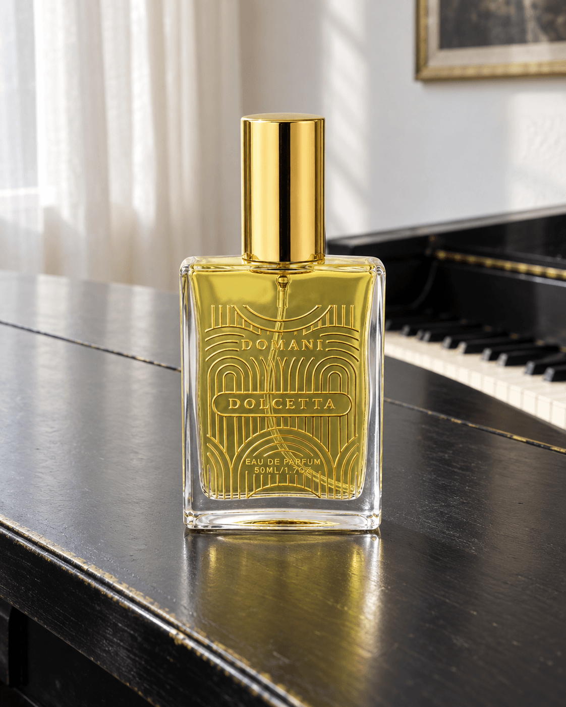 Domani Dolcetta 50 ml bottle with gold artwork and yellow liquid on a black piano lid, with a keyboard and pale curtain behind.